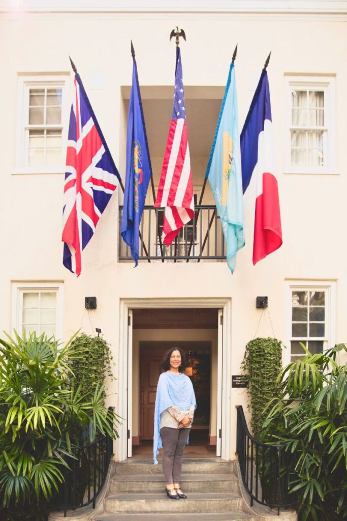 marie josephine royall standing in front of doorway under flags
